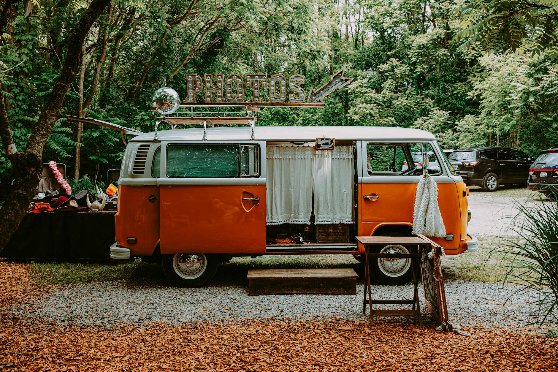 Charming vintage Volkswagen van photobooth in a lush outdoor setting, perfect for events.