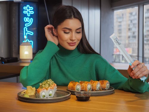 Smiling Woman Sitting at the Table with Sushi