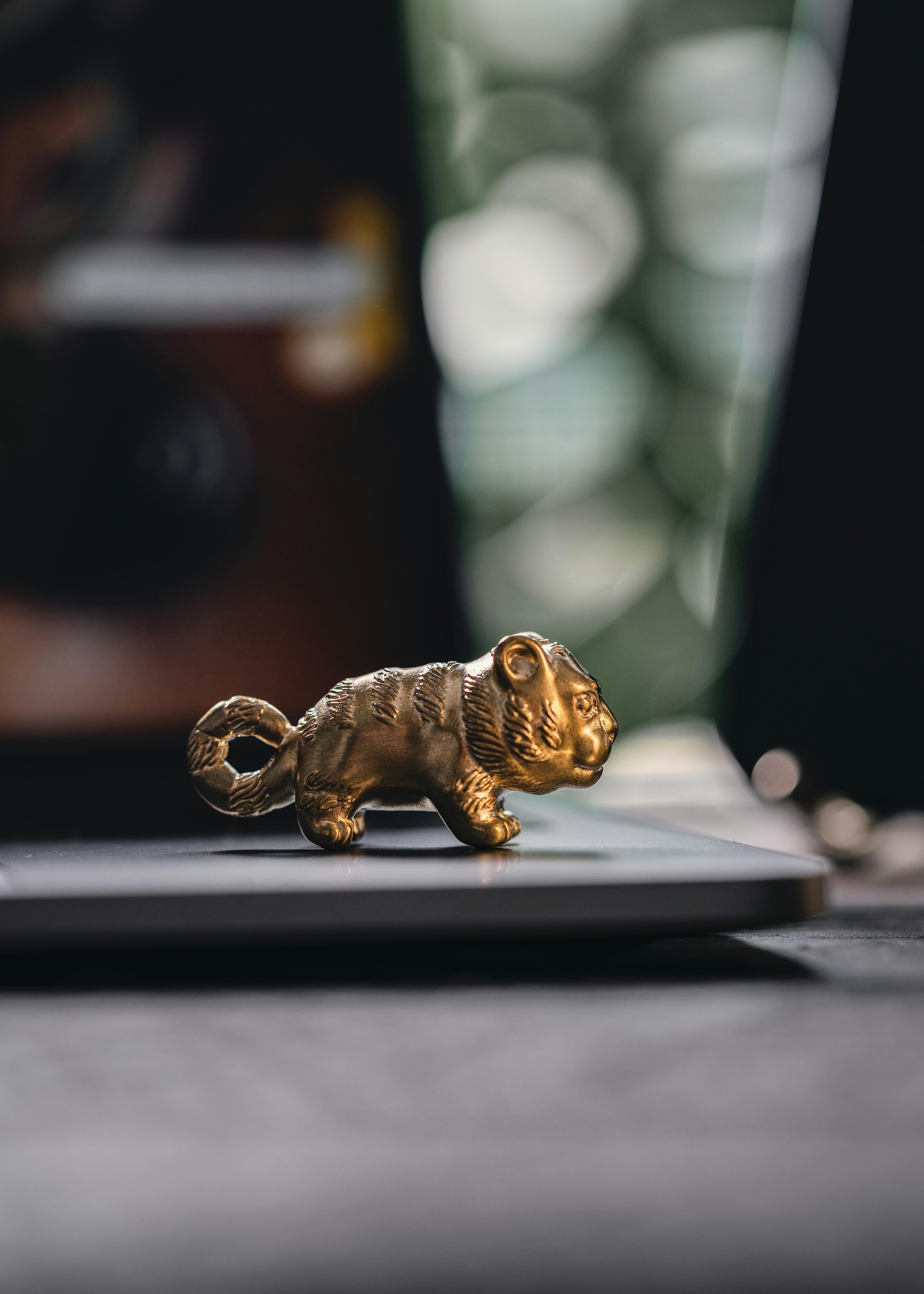 Golden tiger figurine placed on a desk with a soft-focused background, creating a vintage still life.