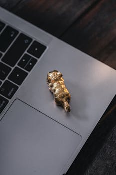Golden tiger figurine on laptop touchpad, creating a unique still life with a touch of elegance.
