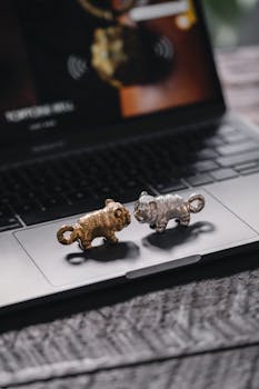 Close-up of gold and silver tiger figurines on a laptop, showcasing intricate metalwork.