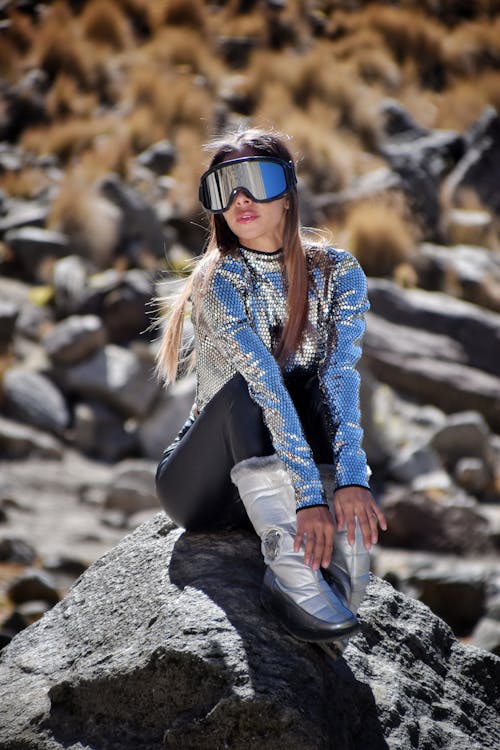 Woman Sitting on Rock, Wearing Goggles