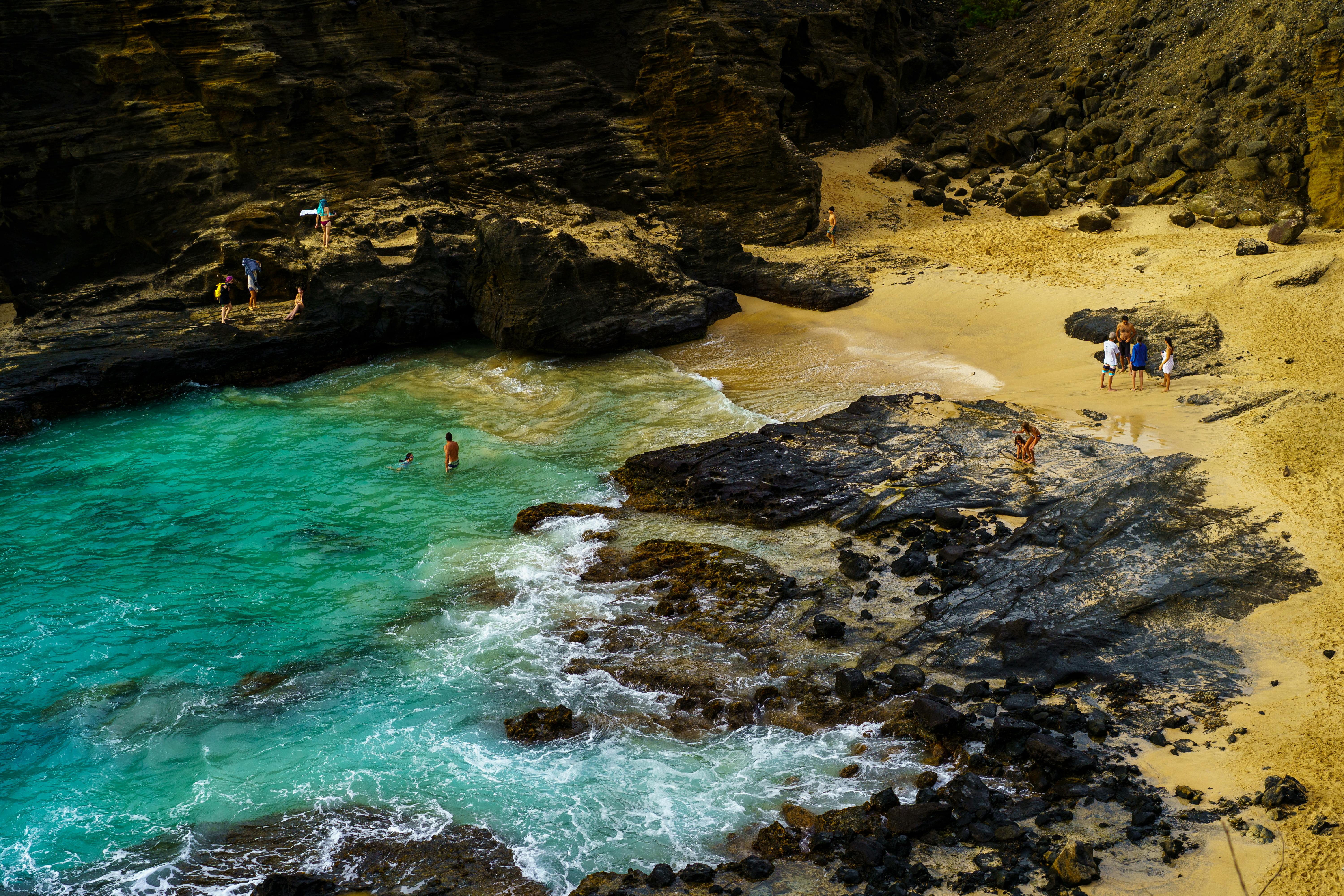 Beautiful beach cove with clear turquoise waters and people enjoying the scenic shoreline.