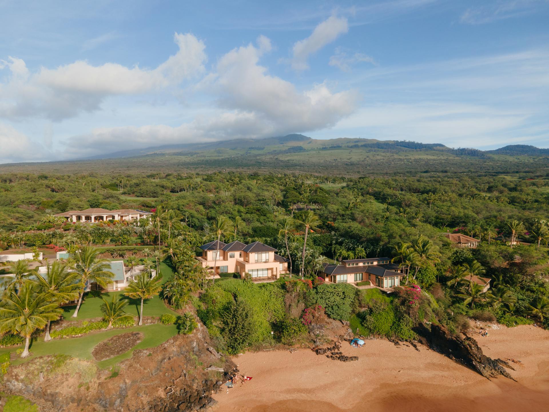 Aerial shot of beachfront houses surrounded by lush greenery in Kihei, Hawaii.