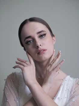 A striking portrait of a young woman with an elegant pose and soft expression.