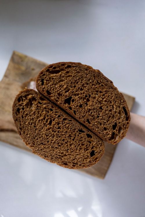 Free Close-up view of freshly sliced brown bread on a wooden board, highlighting texture. Stock Photo