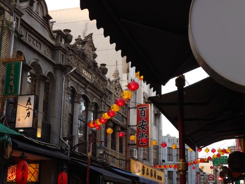 Free Vibrant urban street featuring Chinese architecture, lanterns, and shop signs. Stock Photo