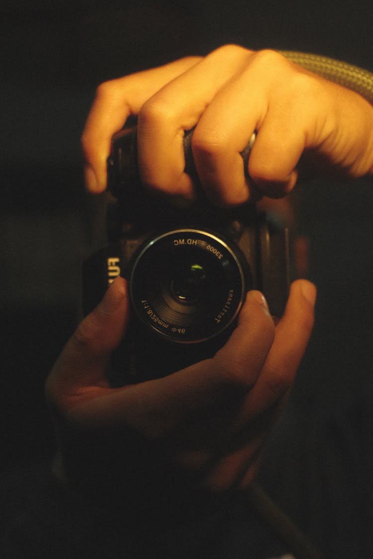 Photo Of A Camera Held By Two Hands Of A Person