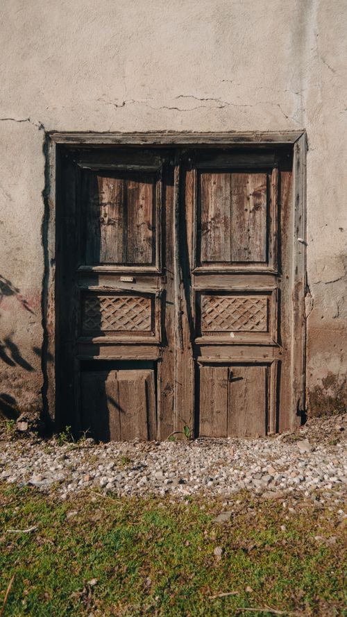 Free Vintage wooden door on a rustic stone building with weathered textures, perfect for backgrounds. Stock Photo