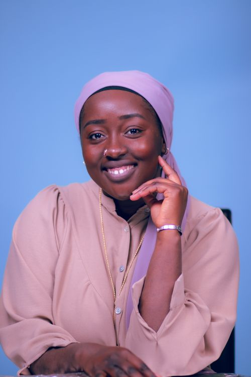 Free A cheerful portrait of a woman wearing a hijab against a blue backdrop, exuding warmth and positivity. Stock Photo
