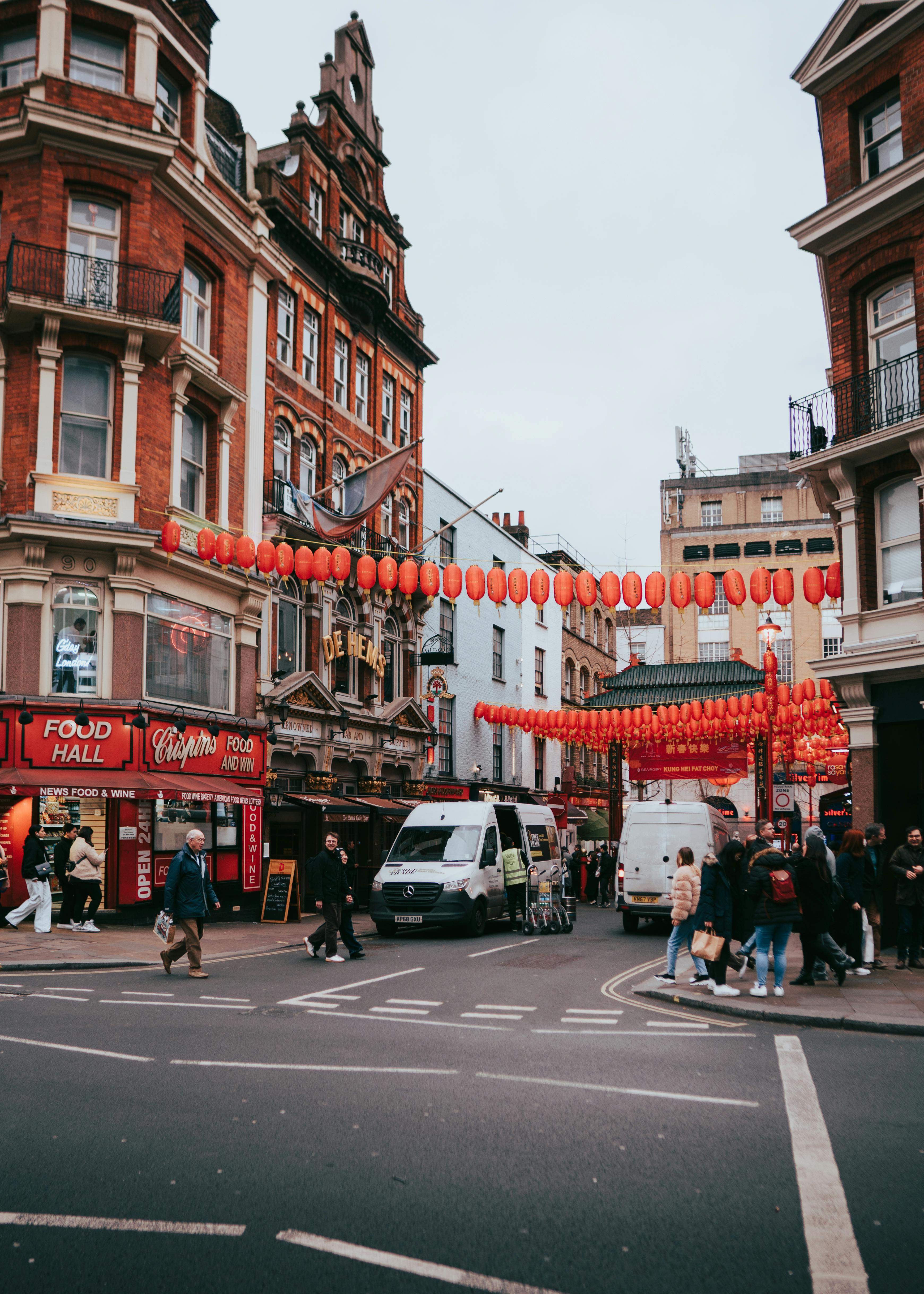 A vibrant city street scene in London's Chinatown with red lanterns and historic architecture.