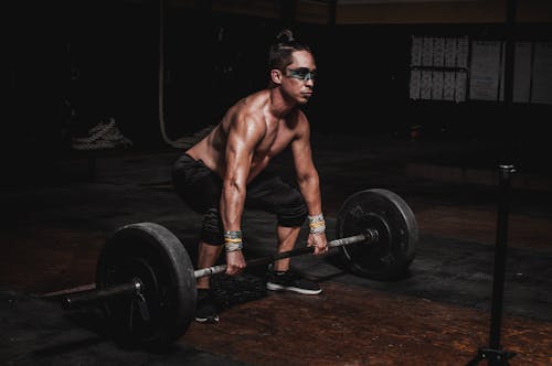 Shirtless Man Lifting Barbell