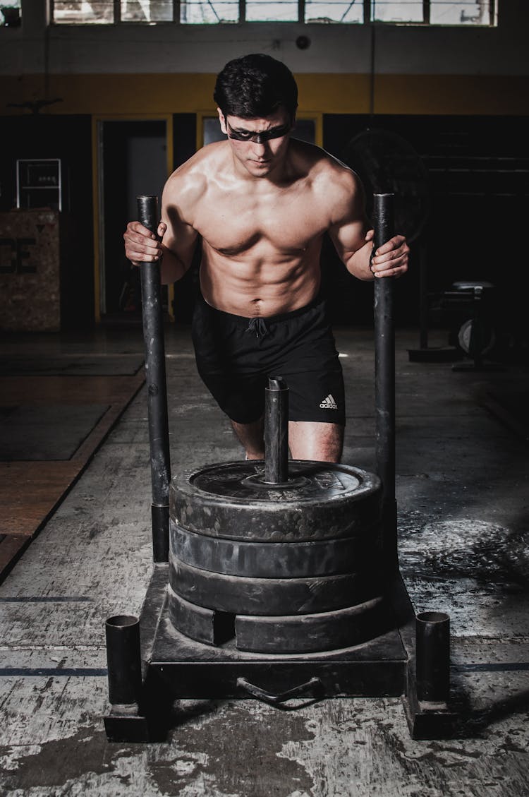 Man Pushing Cart With Weight Plates