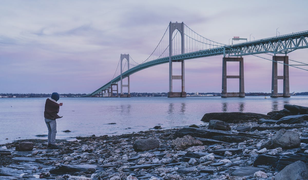 Person walking with a bicycle at sunrise on a path