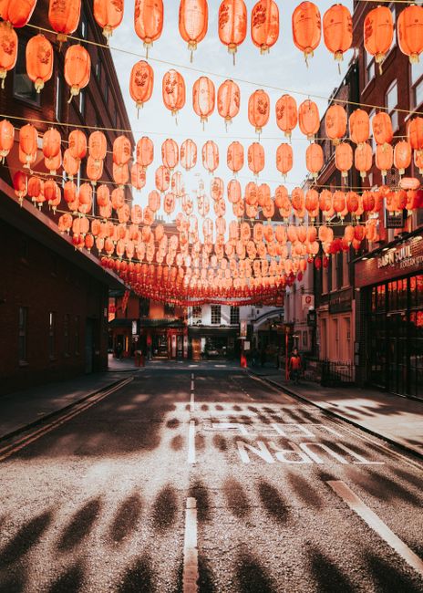 Red lanterns hang in London's Chinatown, creating a festive urban scene.