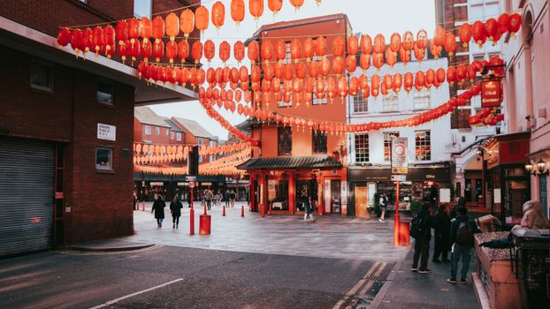 Colorful Chinatown street scene in London with traditional lanterns overhead.