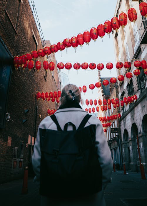 Backpacker Walking under Red Lanterns Hanging over a Street in Chinatown 