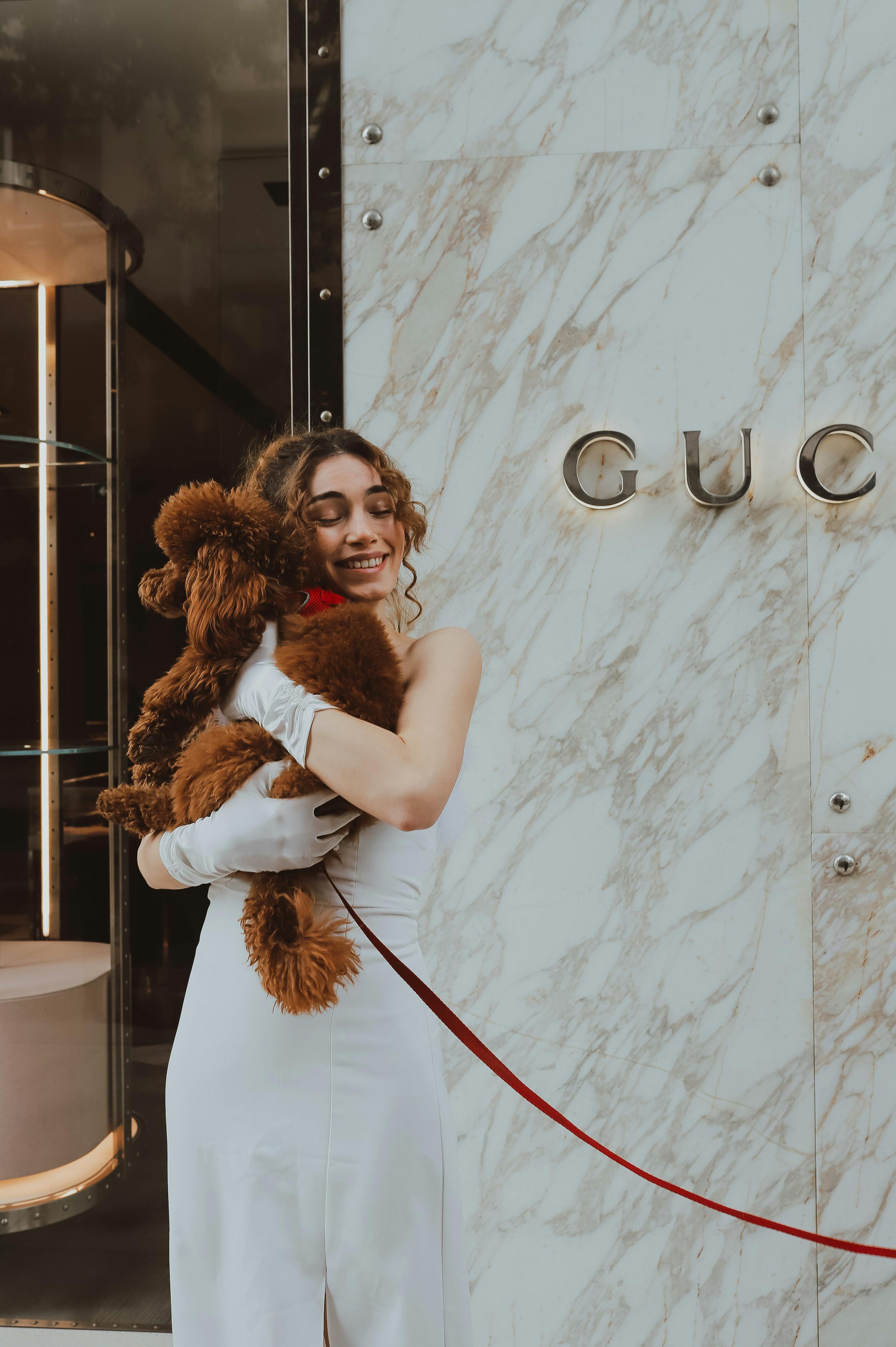 Woman in white gown smiling and hugging her poodle in Istanbul, Türkiye.