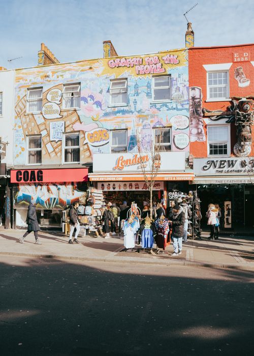 Free Colorful street scene in London featuring vibrant storefronts with artistic murals and shoppers. Stock Photo