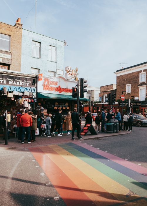 Free A bustling Camden Town street scene featuring a rainbow crosswalk and diverse crowd in London. Stock Photo