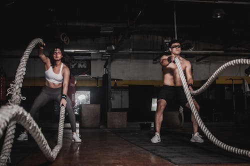 Man And Woman Holding Battle Ropes