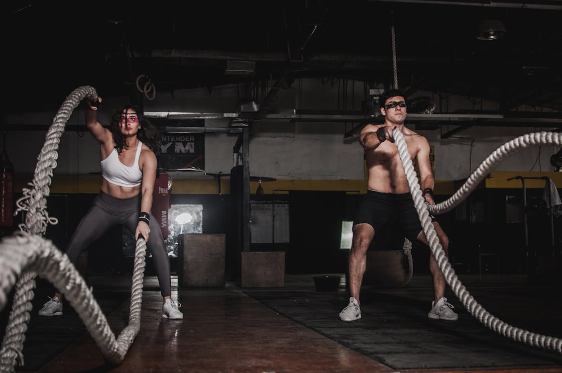 Free Man And Woman Holding Battle Ropes Stock Photo