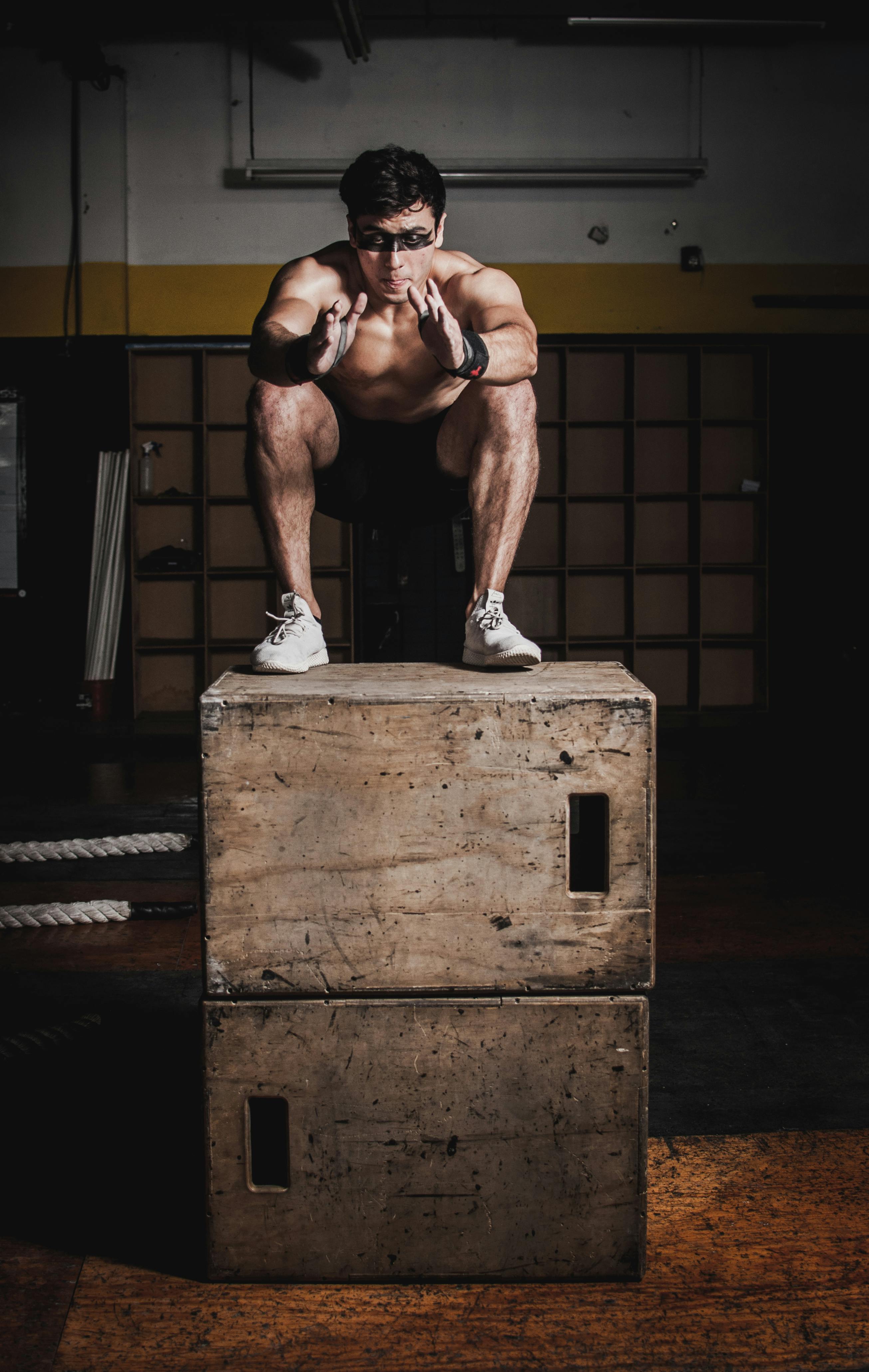 Man Doing Squats On Brown Wooden Box