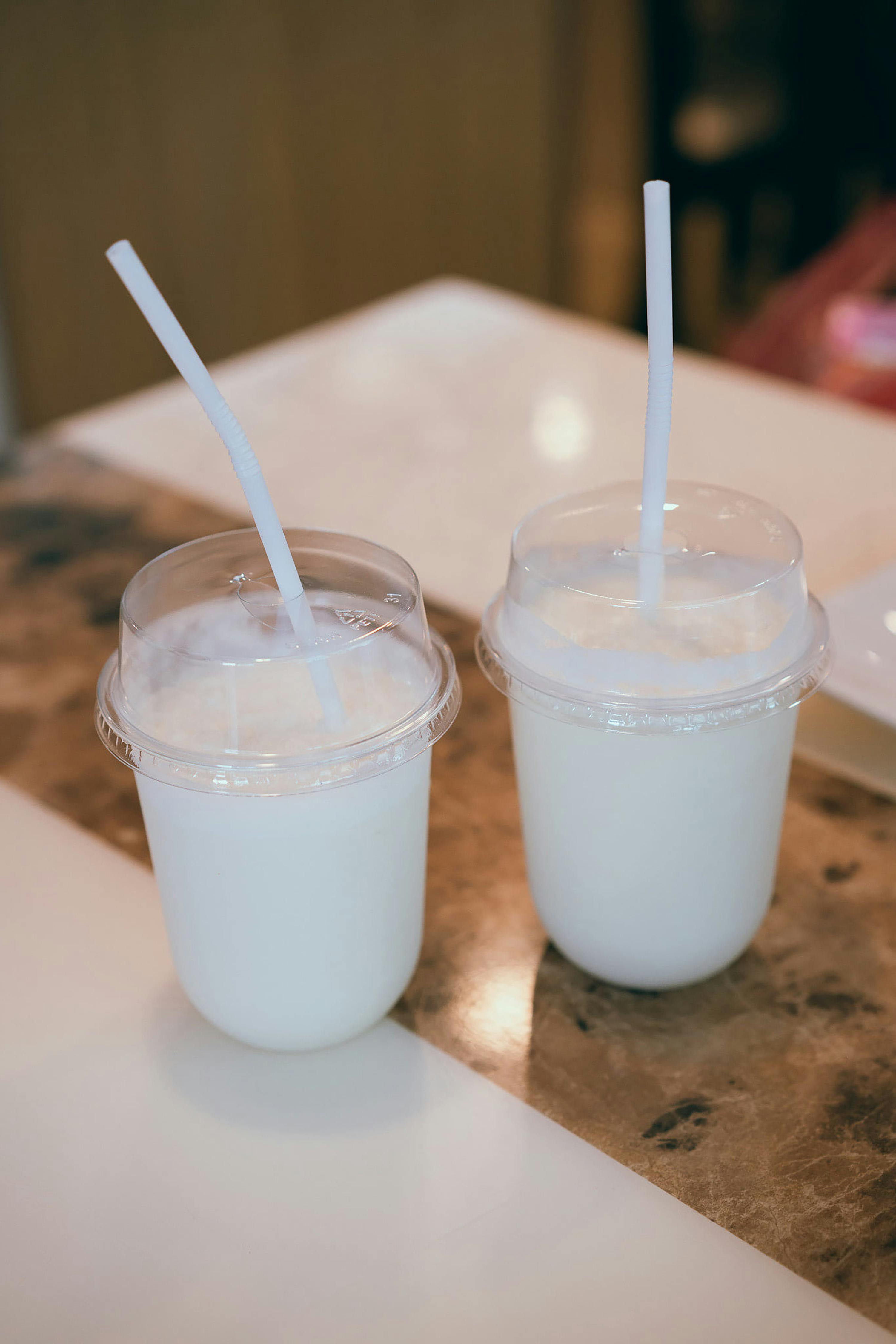Free Two cups of milk with straws on a counter Stock Photo