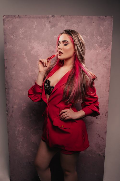 Free Stylish woman poses confidently in a red blazer and lingerie, showcasing modern fashion. Stock Photo
