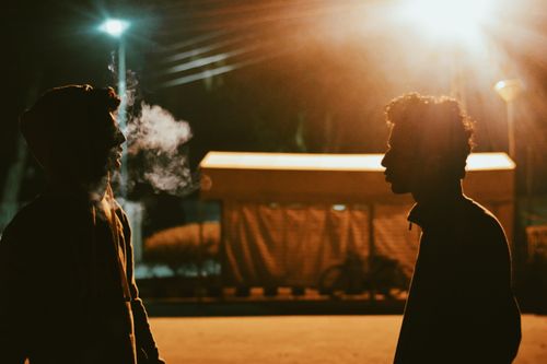 Free Silhouette of two men talking under streetlights in Taxila, Pakistan at night. Stock Photo