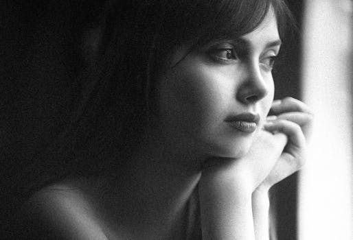Introspective black and white portrait featuring a woman's thoughtful expression.