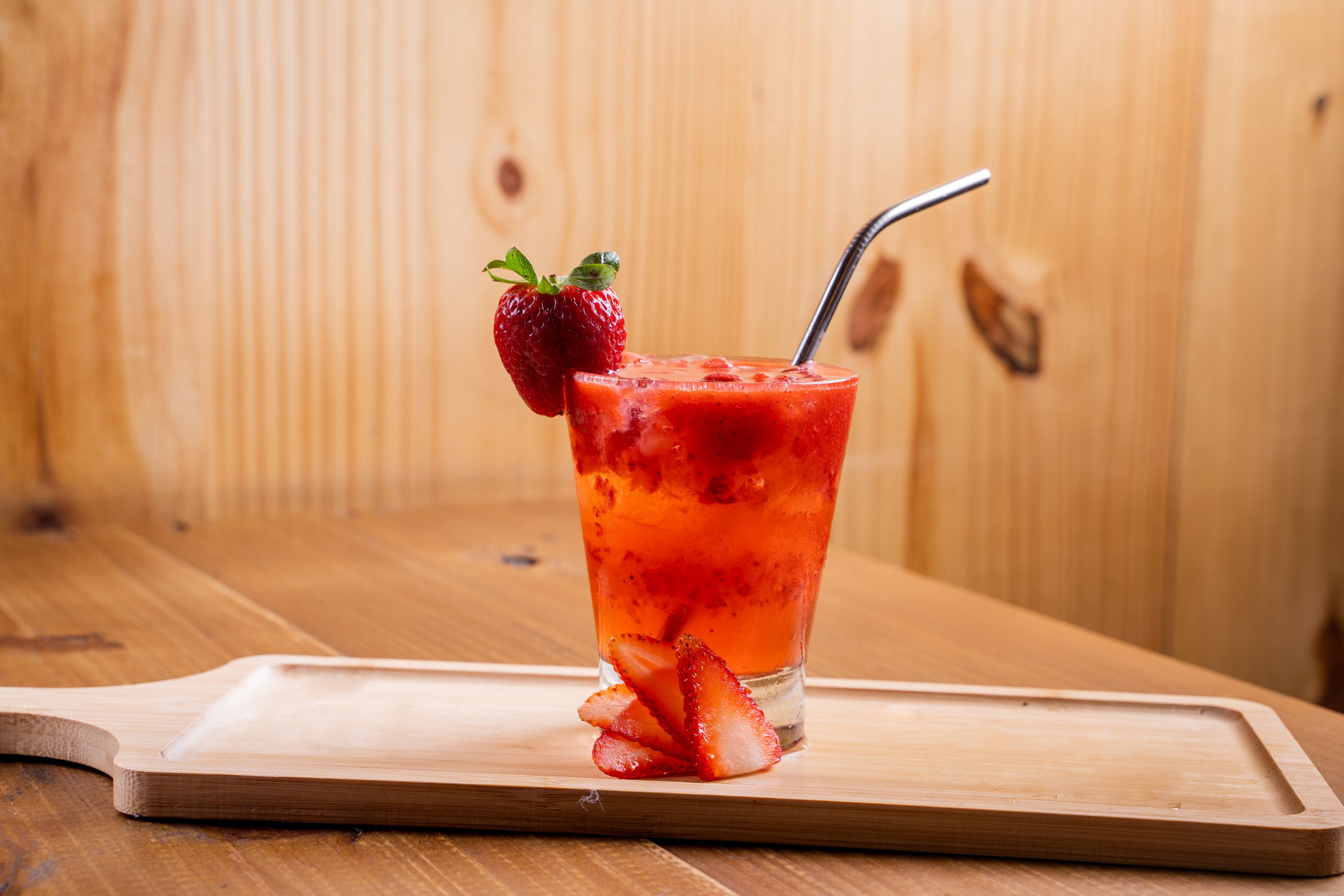 Fresh strawberries and chamomile flowers on a wooden table