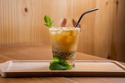 Free A delicious iced beverage garnished with mint leaves on a wooden tray, perfect for a summer refreshment. Stock Photo