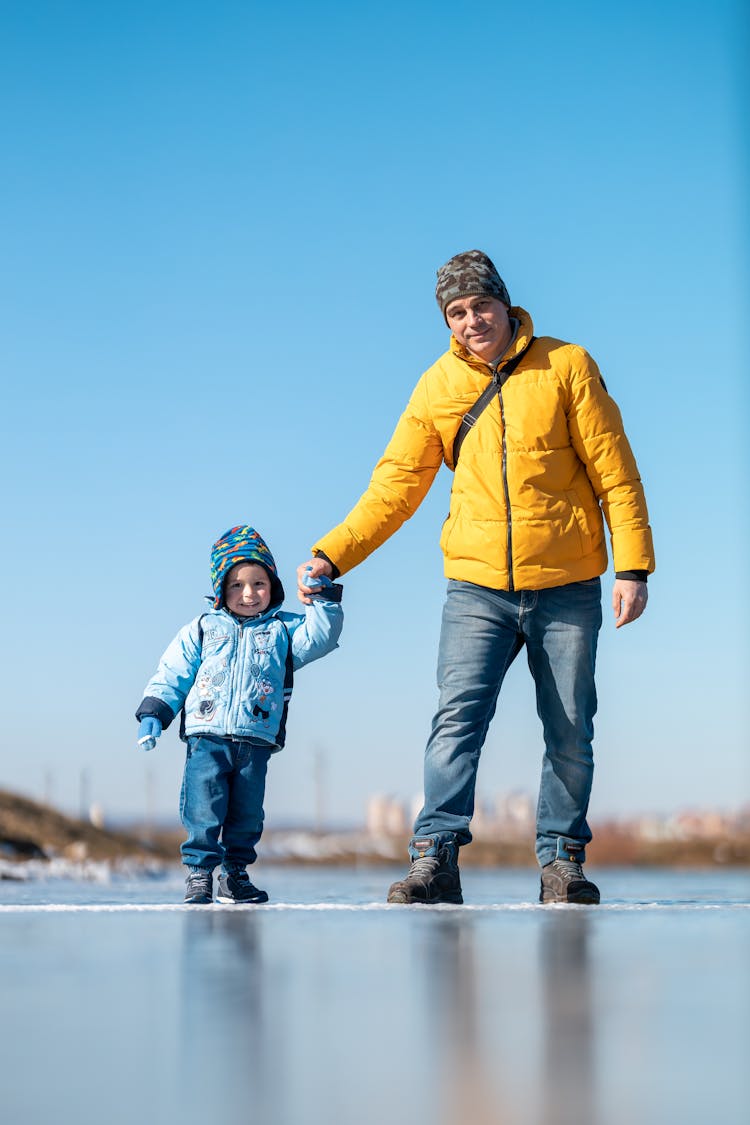 Parent Helping Child Skate On Ice