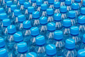 Stacked plastic water bottles with blue caps — photo by Jan van der Wolf on Pexels