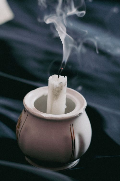 Free Close-up of a white candle extinguished with smoke rising in a porcelain dish. Stock Photo