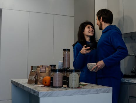 A man and woman in blue pajamas standing in a kitchen