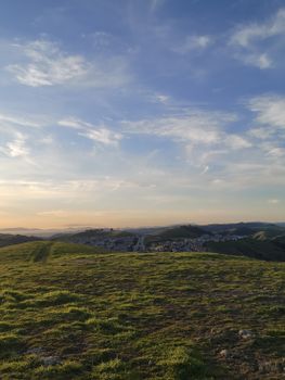 A beautiful grassy plateau with mountains in the distance during a summer sunset.