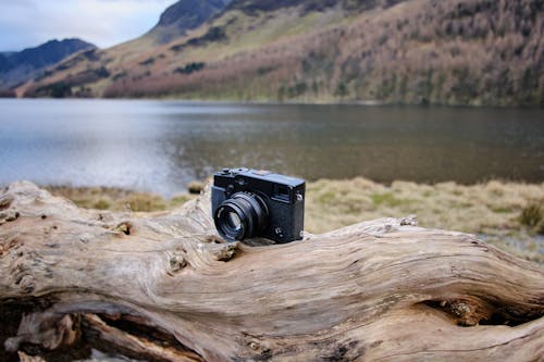 Close-up of a Fujifilm X Pro Camera Standing on a Tree Log by the Water 