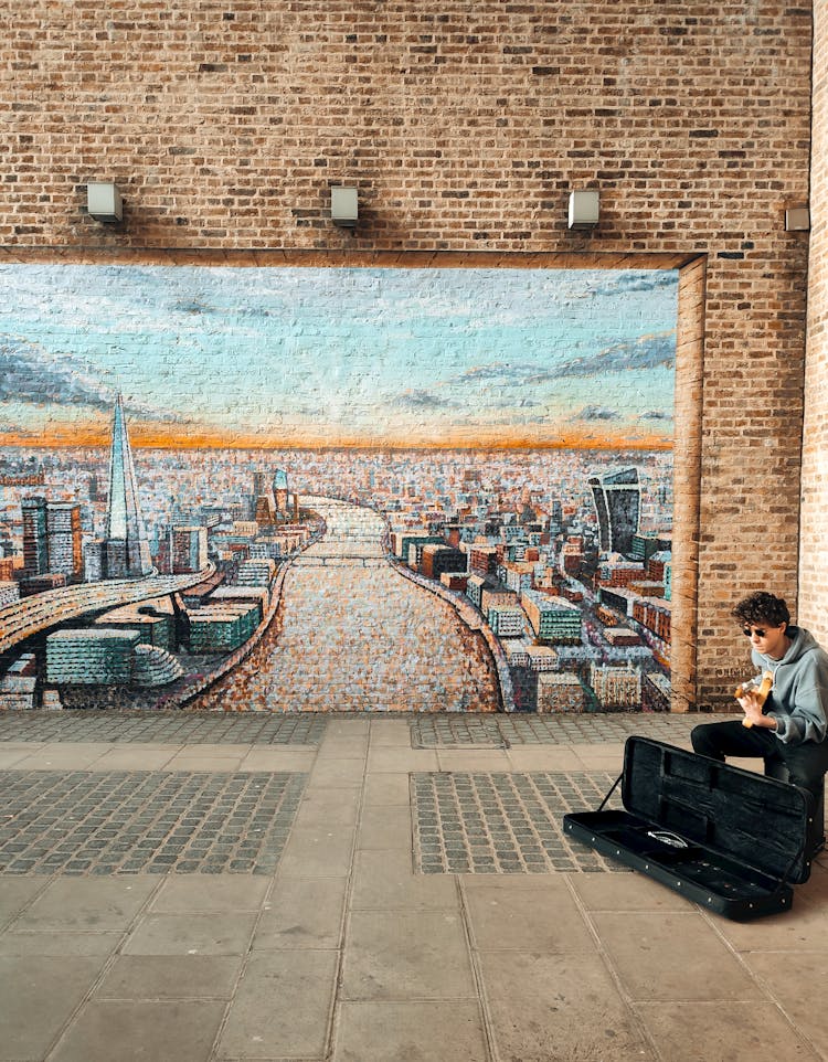 Musician On Sidewalk By Mural