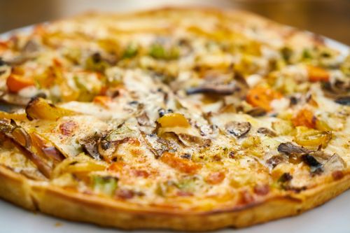 Free Mouth-watering close-up of a freshly baked veggie pizza with mushrooms and bell peppers. Stock Photo