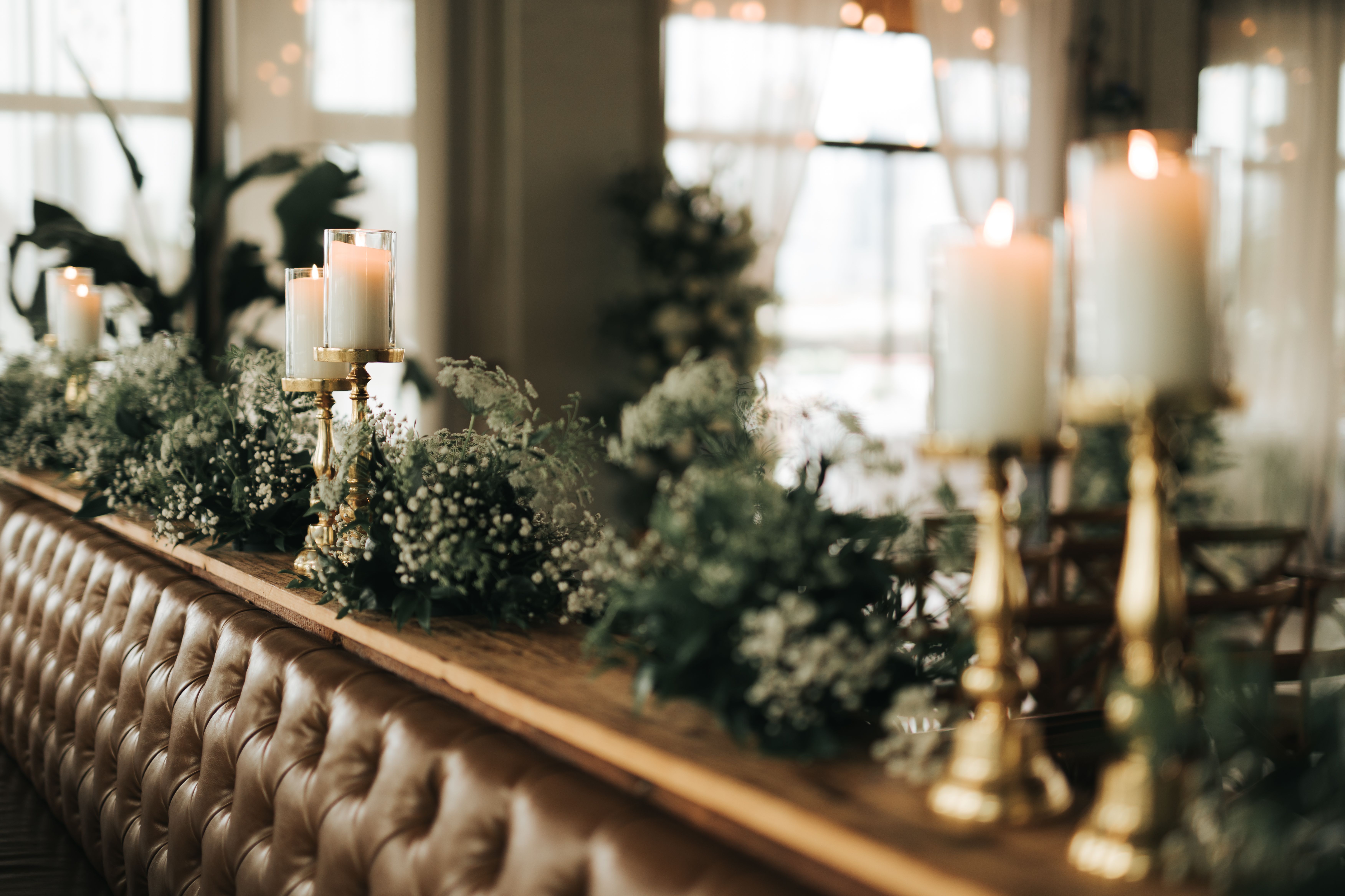 A luxurious table setting adorned with candles and greenery creates an inviting atmosphere indoors.