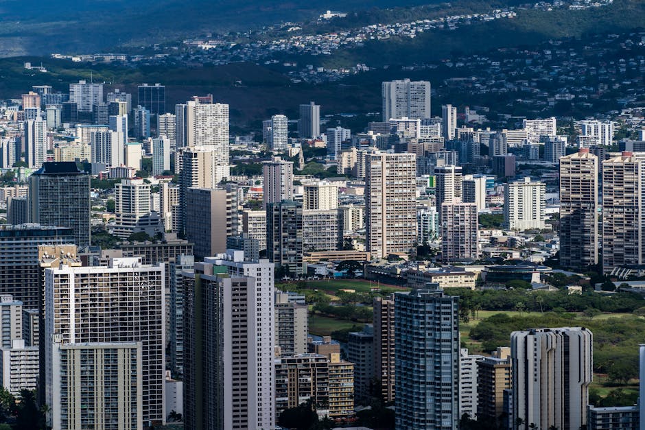 Photo by Cyrill Stunning aerial shot of Honolulu's urban skyline featuring towering skyscrapers and lush surroundings.