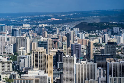 Aerial view of Honolulu's modern skyline with skyscrapers under clear blue skies.