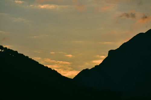 Free A scenic view of mountains silhouetted against a vibrant sunset sky, capturing the essence of nature's beauty. Stock Photo