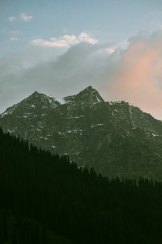 A breathtaking view of a mountain peak under a cloudy sky at dusk.