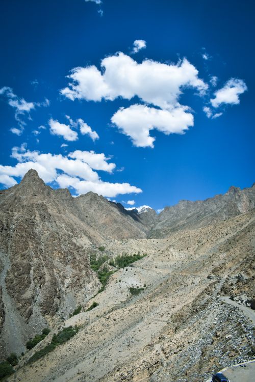 Free A breathtaking view of rugged, arid mountains under a pristine blue sky with scattered clouds. Stock Photo