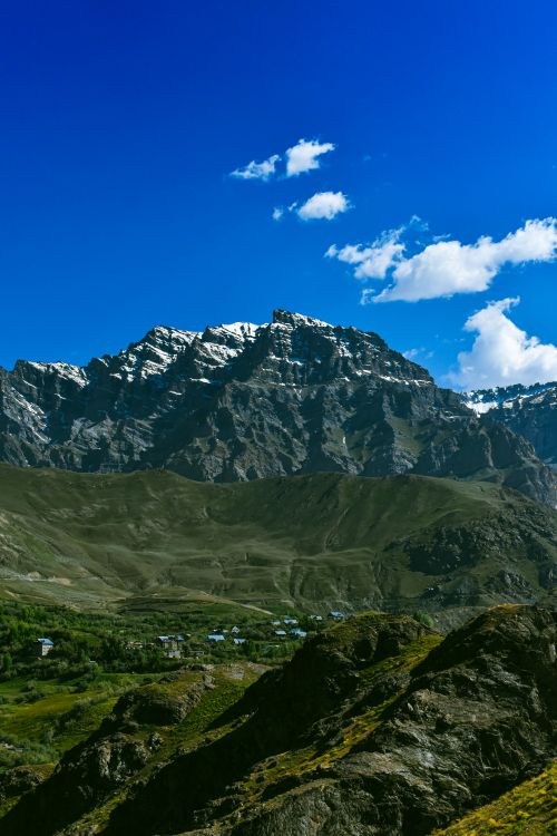 Free A stunning view of snow-capped mountains under a vibrant blue sky, showcasing nature's beauty. Stock Photo