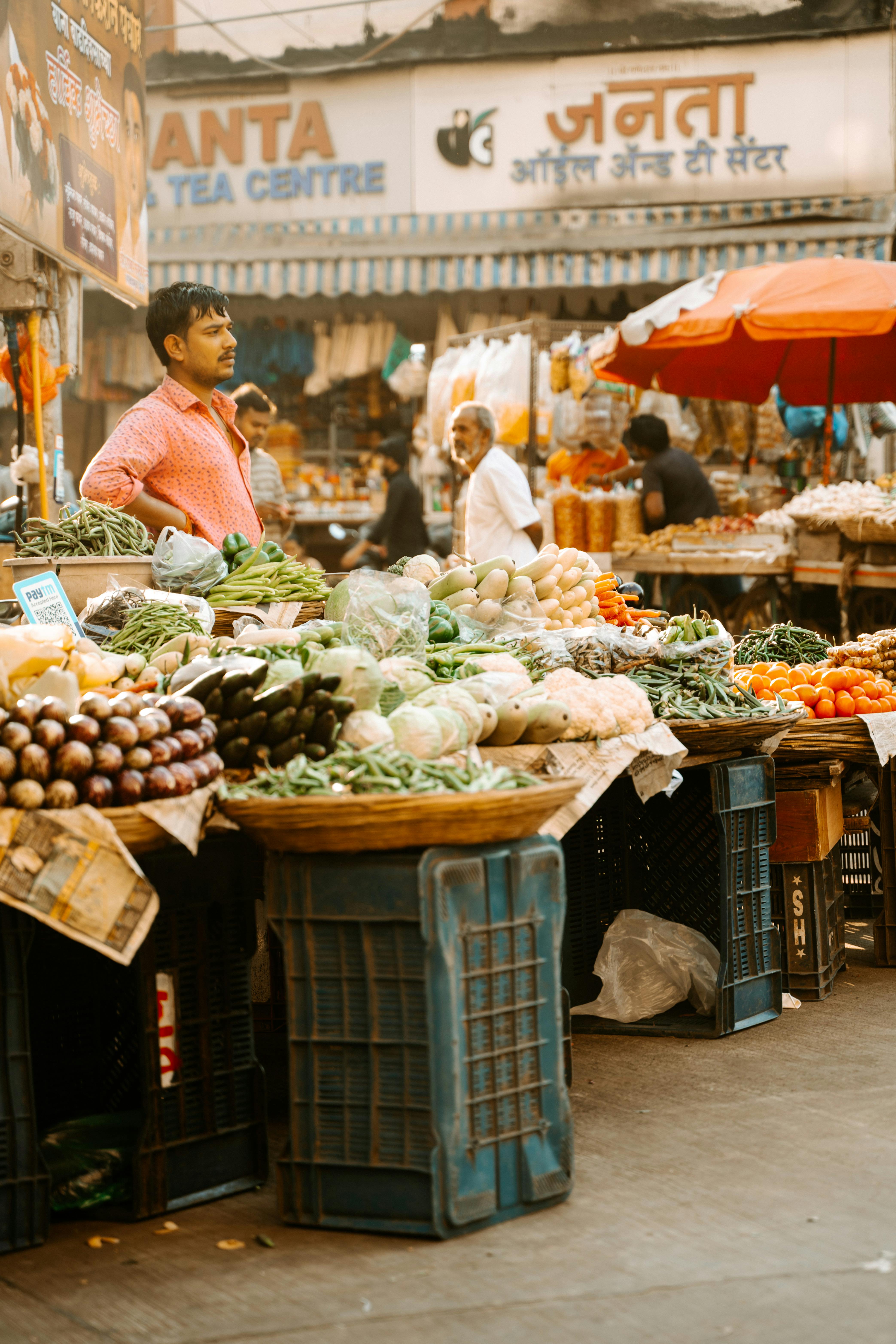 Bustling Indian market with colorful vegetable stalls and busy vendors.