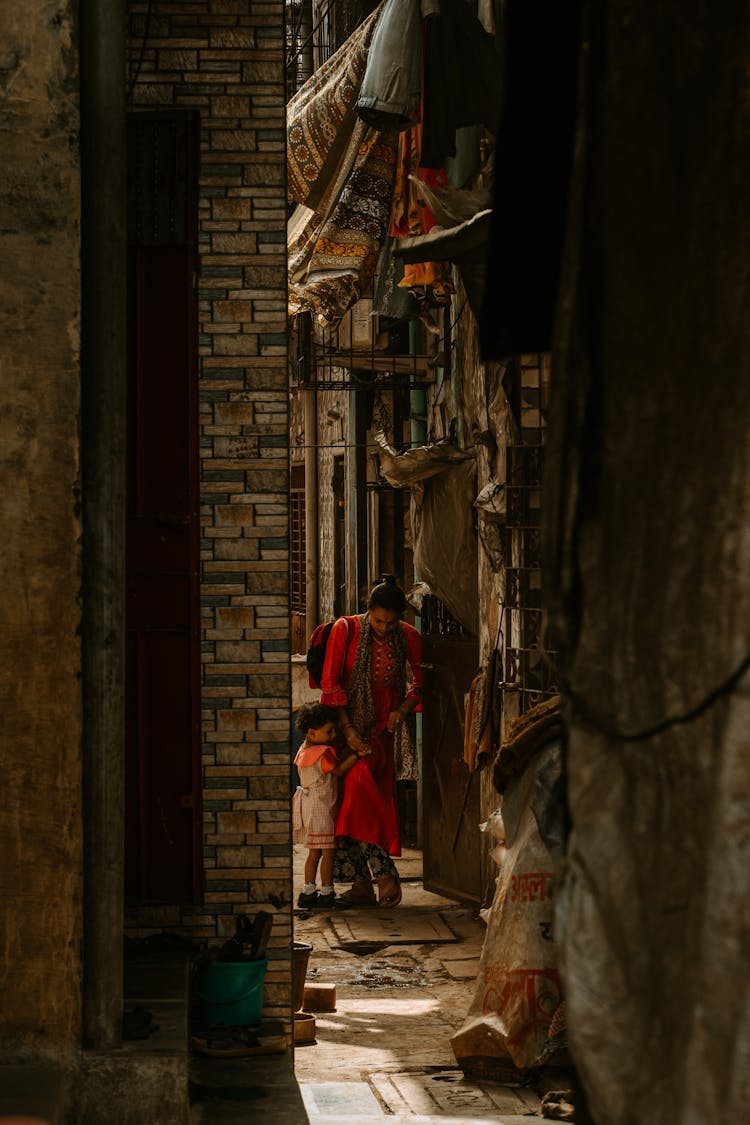 Mother With Kids In Narrow Alley